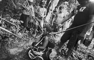 部落成员抓住一名淘金者，其身边还有准备用来装金矿石的袋子。 