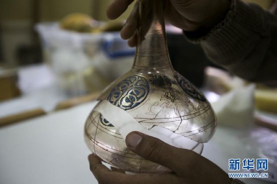 2月9日，在埃及首都开罗，一名博物馆工作人员正在修复受损的艺术品。