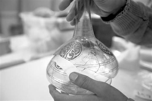 图为9日，一名博物馆工作人员正在修复受损的艺术品。