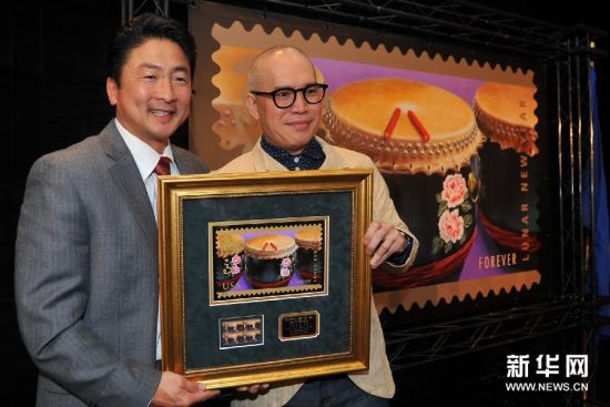 1月15日，在美国旧金山，马年邮票设计师麦锦鸿（右）和首发式主持人艾伦·王手捧马年邮票纪念品合影。　　