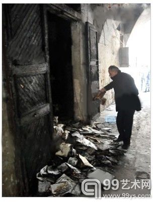 图为相关人员正在检查在此次袭击事件中烧毁的典籍。