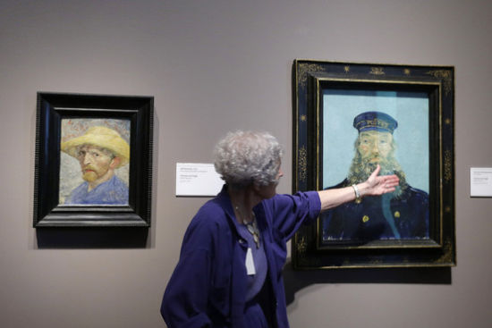 2013年6月13日，底特律艺术学院讲解员Lea Schelke在讲解梵高《邮递员鲁伦》的细节。