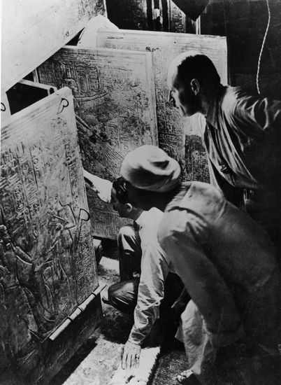 英国考古学家霍华德·卡特（单膝跪者）在法老图坦卡蒙的墓室门口（参与发掘的美国纽约大都会艺术馆的Harry Burton摄）。