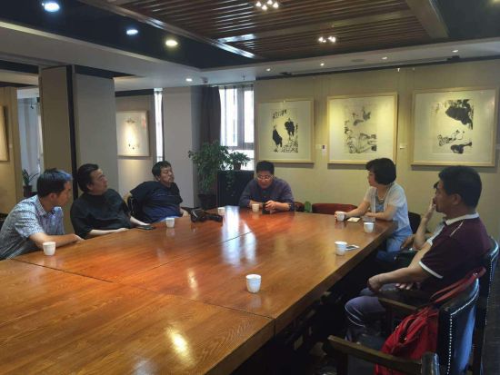 组委会工作人员向西部名家艺术馆介绍南京国际美术展及中艺易购签约平台