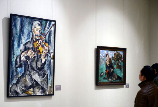 3月6日，参观者在欣赏俄罗斯油画作品《小提琴手》。图片来自新华网