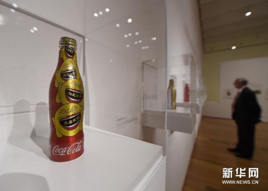 （3）2月26日，在美国亚特兰大高等艺术博物馆举办的“可口可乐弧形瓶”艺术展上，一名参观者了解弧形瓶发展历程。