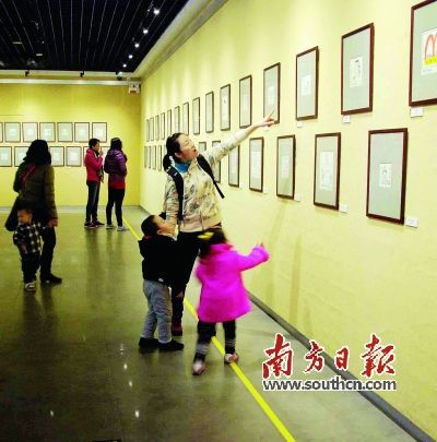  不少家长带着孩子前往欣赏华君武漫画展。资料图片