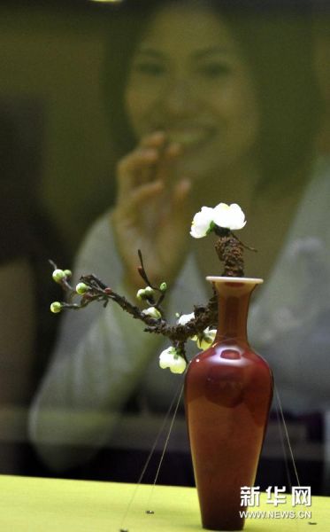 12月24日，观众在台北故宫博物院欣赏清康熙“豇豆红瓷柳叶瓶”。 