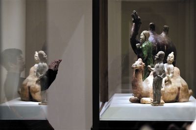 昨日，观众在中国国家博物馆观看唐代的彩绘陶骑卧驼胡俑与牵驼胡俑。 