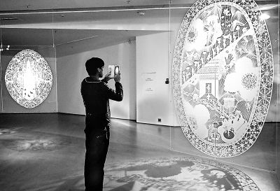 “纸的对话——龙和我们的故事”展览现场，一位参观者在挪威艺术家凯伦·碧特·维乐的作品前拍照。