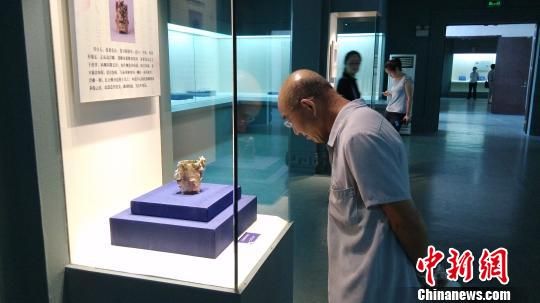 市民在欣赏青白玉朱雀踏虎衔环纹卮。8月15日，“安徽汉代玉器精华展”在安徽省博物馆开幕，共精选了来自安徽省境内出土的汉代玉器140余件。　茆振杰　摄