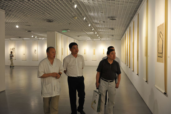 随牟陪同北京文化发展基金会秘书长秦昌桂（中）参观展览