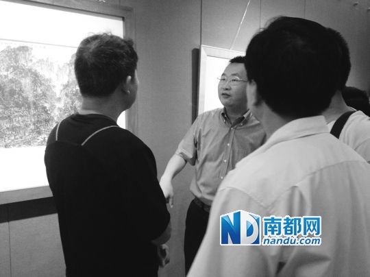 台山市委常委、宣传部部长邝俊杰(面对镜头者）和画家陈钠（黑色衣服)观看展览。南都记者 梁晓琳 摄