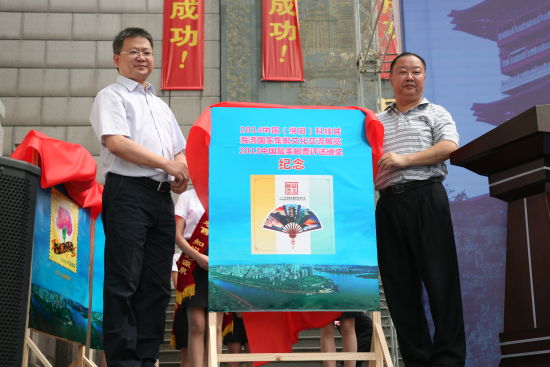 绵阳市人大主任张世虎（右）与四川省邮政公司副总经理唐华建（左）为纪念册揭幕