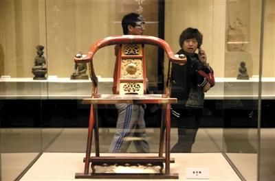 昨日，中国园林博物馆，“坛庙撷英”展，两位游客从“金交椅”前走过。新京报记者 薛珺 摄 