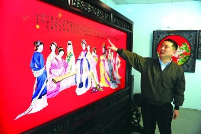中国红瓷器发明人尹彦征和他设计的《金陵十二钗》中国红瓷板画。  杨华峰 摄