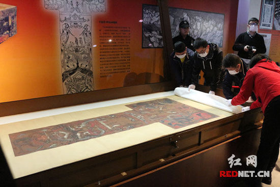 (湖南省博物馆工作人员正在布展国家一级文物T形帛画。)