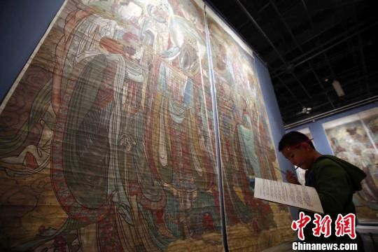 “永乐宫元代壁画临摹作品展”20日在山西博物院开幕，图为一名小学生在画作前临摹。 张云 摄