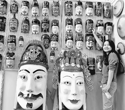 观众被环江县民间工艺师手工雕刻的毛南族傩面面具作品所吸引。