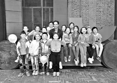 　　提诺·赛格尔的作品不允许现场拍照或录像。图为他与招募的中国孩子“引导员”合照。 尤伦斯当代艺术中心供图