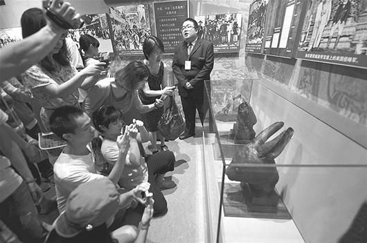 图为7月21日，鼠首兔首的展柜被团团围住，游客争相拍照留念。 （中新社发）