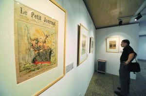 昨天下午，一名观众在中华世纪坛世界艺术馆内认真观看一百多年前反映日俄战争场面的画刊版画，彩色写实的版画不但有很高的历史价值，而且艺术价值不菲。 本报记者 和冠欣摄