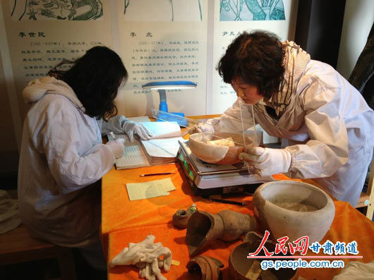 天水市博物馆工作人员正在对甘肃省文物考古所移交的大地湾文物进行入账登记。（杜昱欣 摄）