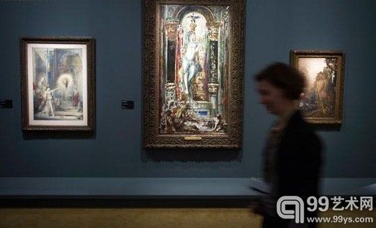 一名女士正在经过展览中展出的居斯塔夫·莫罗（Gustave Moreau）作品