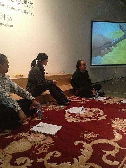 一块代表着中亚的地毯摊在地上，众人聚集在一起，分享彼此对于新疆的关切。