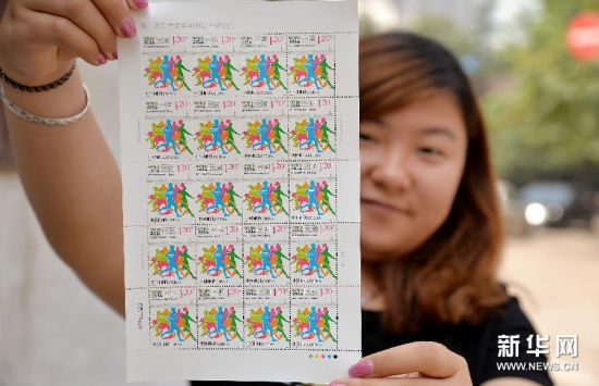 8月15日，河北省邮政公司邯郸市分公司工作人员展示《第二届夏季青年奥林匹克运动会》纪念邮票。