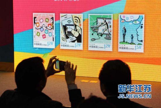 首发式参与者在拍摄大屏幕上展示的《网络生活》邮票影像。