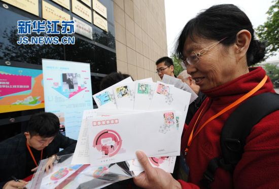 购买《网络生活》邮票及相关邮品的市民排队请邮票设计者贾昆（左）签名。