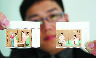 工作人员展示《捣练图》特种邮票 新华社发