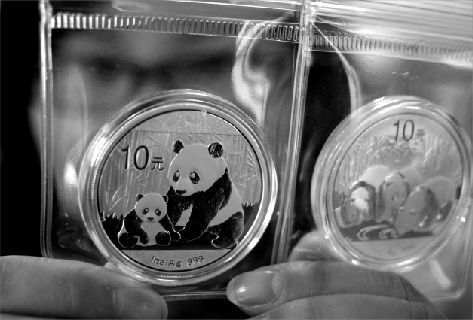 昨日，一位市民展示收藏的熊猫币。本报记者 孙辰 摄