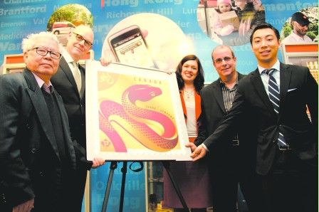 加拿大邮务公司代表、邮票设计师及全加华人平权会代表8日共同为蛇年邮票揭幕。(加拿大《明报》)