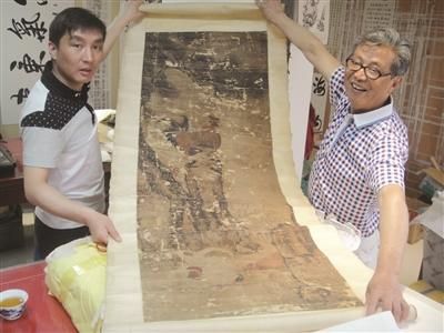 杨老父子展示待修复的《松鸡图》。 万凌云 摄