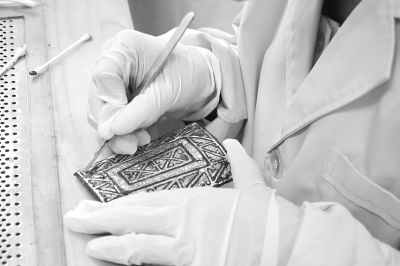 甘肃省文物考古研究所的专业人员正在修复马家塬墓地出土的文物 李韵摄