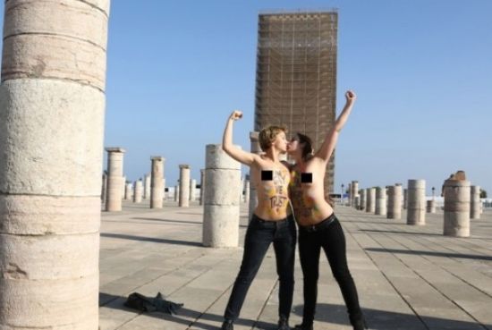 两女子在摩洛哥一处古迹前拍摄半裸照。图片来源于网络 新浪收藏配图