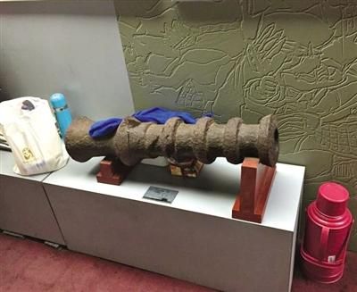 古代钱币展览馆，一古炮旁放着水壶等物品，还有一块抹布搭在铁炮上。新京报记者 李馨 摄