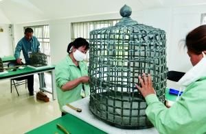 工人们正在清理皇宫内的生活用品“笼罩”，它们的具体功用还需进一步考证。北京晨报记者 李木易/摄