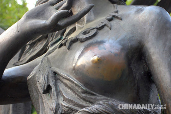 图为雕塑被游客摸得蹭光发亮。