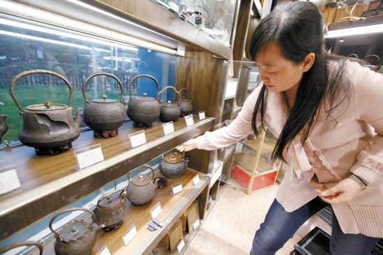 在椒江一家铁壶商铺，一名女士正在打量日本铁壶。