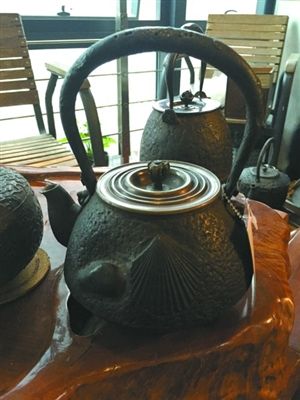 张放收藏的铁壶，上面有贝壳花纹，提梁为中空的，上面有虫蛀纹。