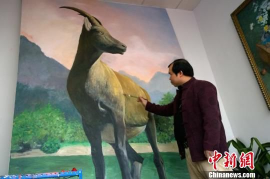 2月3日，广西画家宁学在南宁鼎鸿书画院内完善油画“巨羊图”。王刚 摄