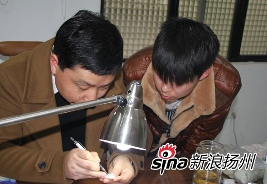 图为冯龙军教徒弟画玉技巧