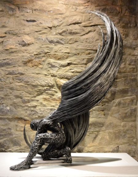 艺术家用金属丝所制成的人形雕塑，宛如一只即将展翅高飞的带翅膀的人。