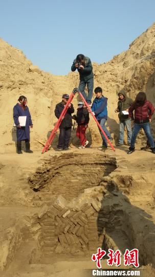 图为考古人员在为一个圆形古墓拍摄俯视图留作备案资料。　刘冰　摄