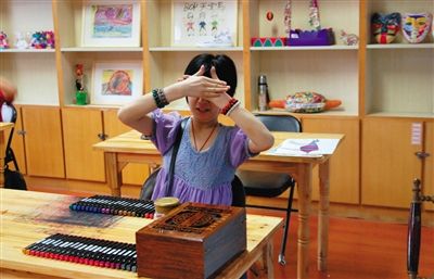 在郭海平的工作室，精神病患者被称呼为画家，一位画家有点不好意思，挡住了脸。受访者供图