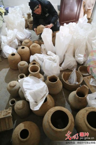 2014年1月5日，考古工作者在驻地仓库清理出土的陶器。