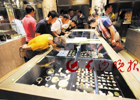 长沙市文物商店内，众多古玩爱好者在品鉴琳琅满目的文物。 长沙晚报记者 王志伟 摄